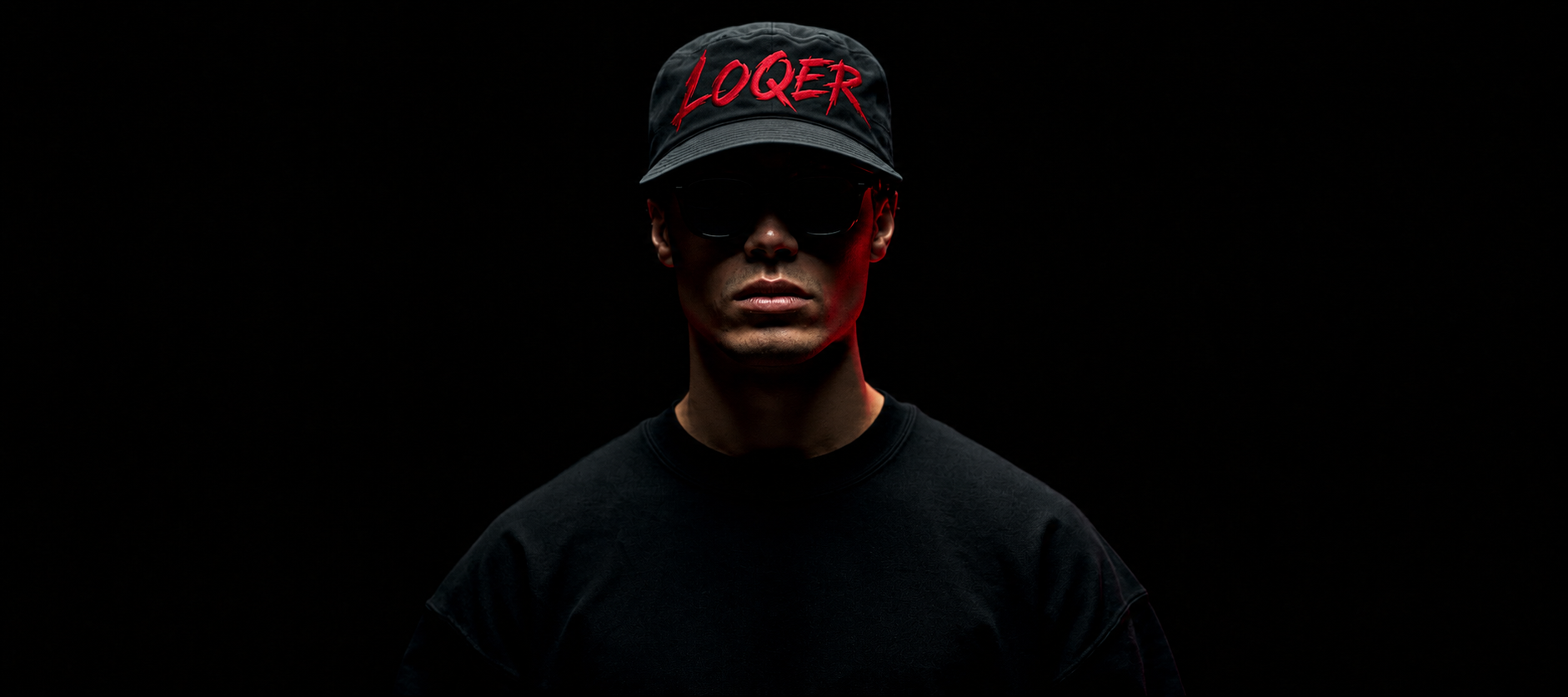 Человек в кепке LOQER на тёмном фоне